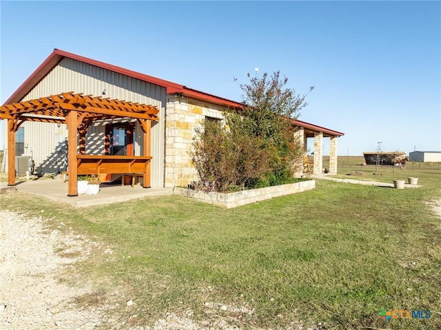 view of side of home with a yard and a pergola