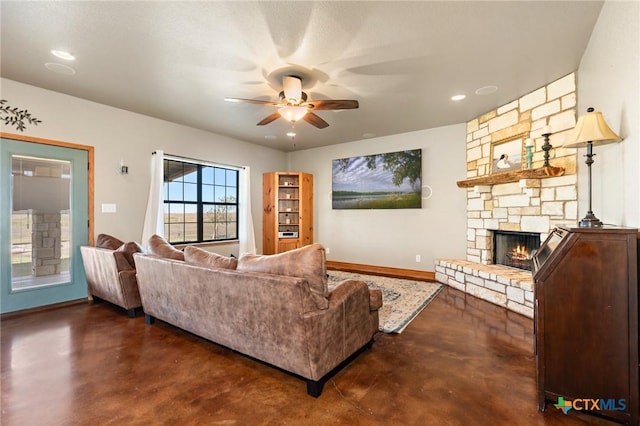 living room featuring ceiling fan and a stone fireplace