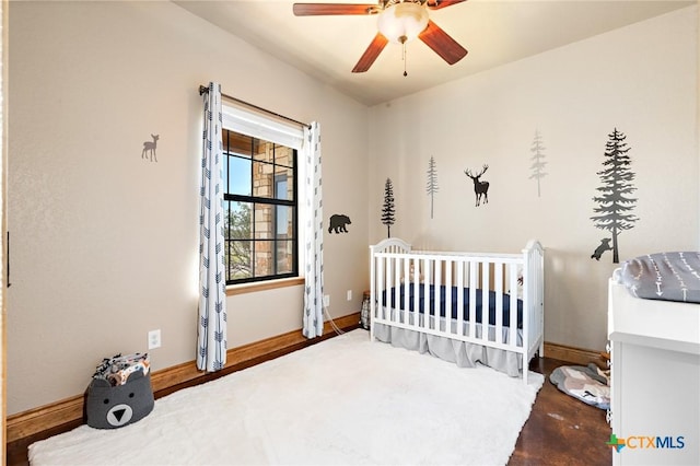 bedroom with ceiling fan and a crib