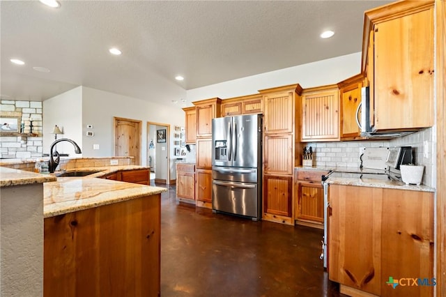 kitchen featuring light stone countertops, sink, vaulted ceiling, decorative backsplash, and appliances with stainless steel finishes