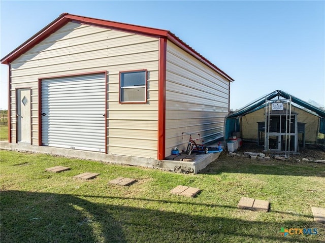 view of outbuilding with a garage and a yard