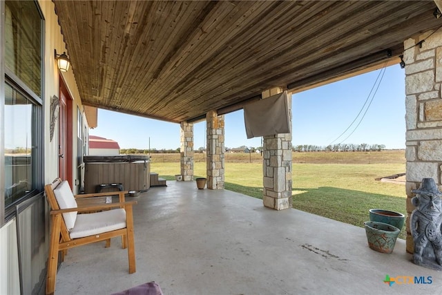 view of patio / terrace with a rural view and a hot tub