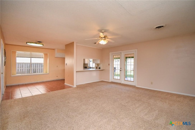 unfurnished living room featuring light colored carpet, french doors, and ceiling fan