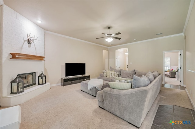 1921 Merlin Dr, Harker Heights, TX 76548 - carpeted living area with a ceiling fan, arched walkways, ornamental molding, a large fireplace, and baseboards