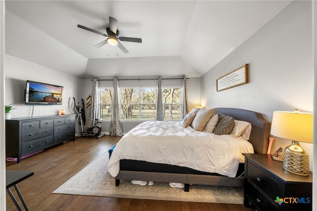 bedroom with dark hardwood / wood-style flooring, vaulted ceiling, and ceiling fan