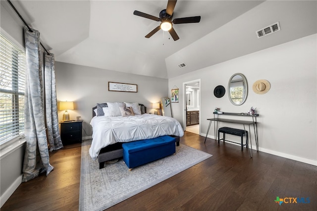 bedroom featuring lofted ceiling, dark wood-type flooring, connected bathroom, and ceiling fan