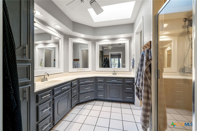 bathroom with ceiling fan, tile patterned floors, a skylight, and vanity