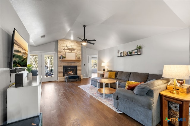 living room with lofted ceiling, wood-type flooring, a fireplace, and a healthy amount of sunlight