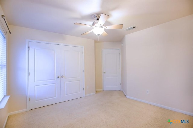 unfurnished bedroom with visible vents, a ceiling fan, a closet, baseboards, and light colored carpet