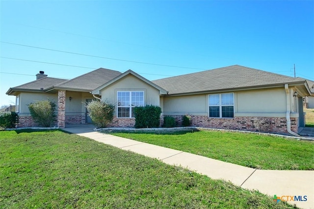 ranch-style home featuring a front lawn and brick siding