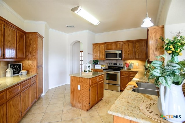 kitchen featuring tasteful backsplash, visible vents, a center island, arched walkways, and stainless steel appliances