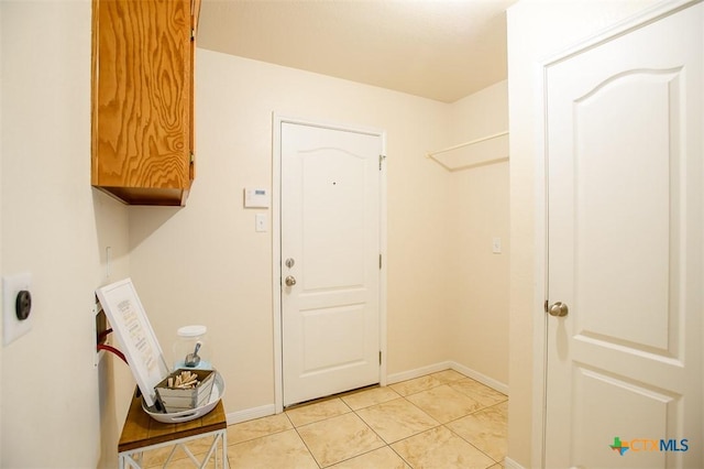 interior space with light tile patterned floors, baseboards, and cabinet space