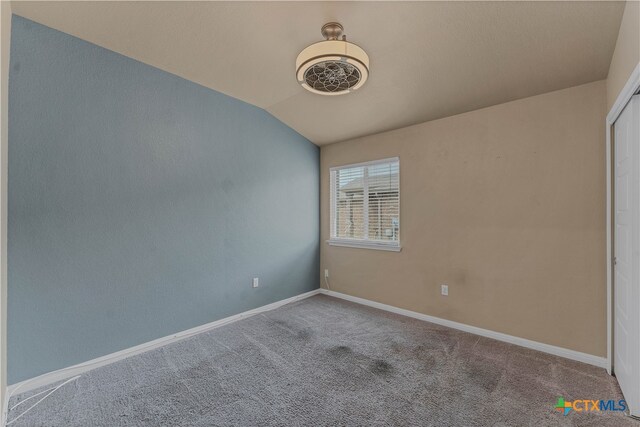 unfurnished room featuring lofted ceiling and light carpet