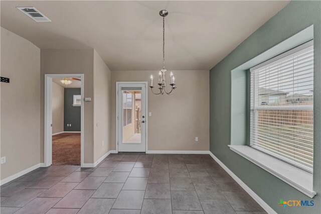 unfurnished dining area with tile patterned flooring and a notable chandelier