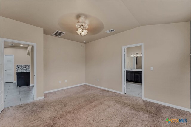 carpeted spare room featuring lofted ceiling and ceiling fan