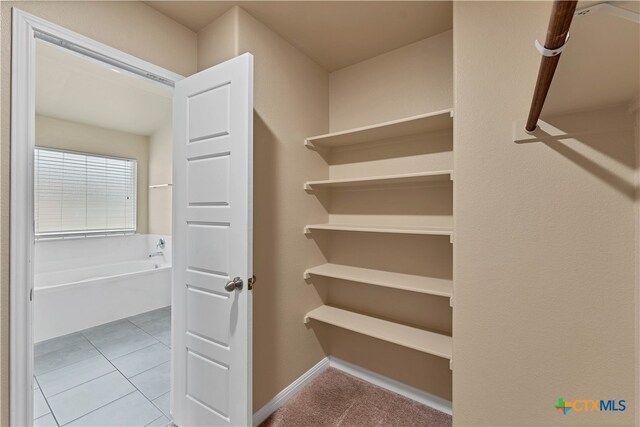 spacious closet featuring light tile patterned floors