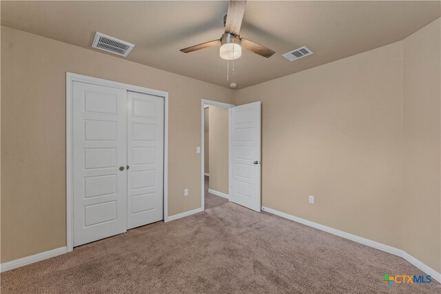 unfurnished bedroom with carpet floors, a closet, and ceiling fan