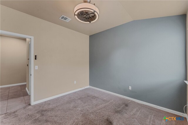 empty room with vaulted ceiling and light carpet