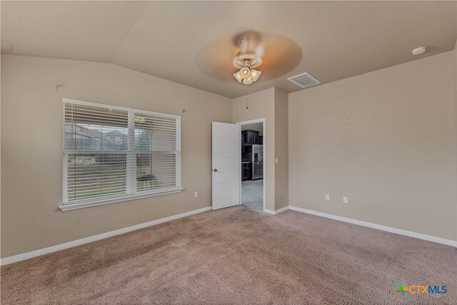 carpeted empty room featuring lofted ceiling and ceiling fan