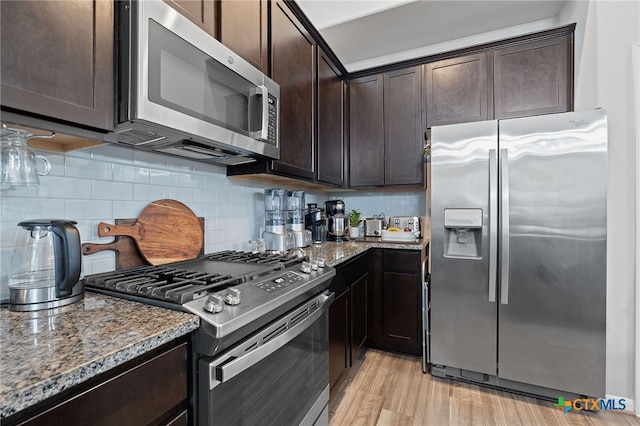 804 Blue Oak Blvd, San Marcos, TX 78666 - kitchen featuring appliances with stainless steel finishes, dark stone counters, dark brown cabinetry, and backsplash