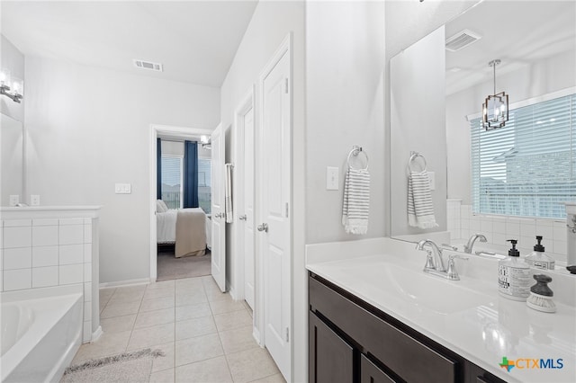804 Blue Oak Blvd, San Marcos, TX 78666 - ensuite bathroom with tile patterned floors, vanity, a bath, baseboards, and a chandelier
