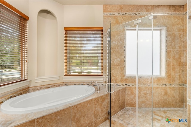 bathroom with a stall shower and a bath