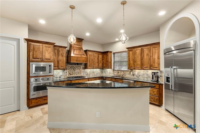 kitchen with premium range hood, brown cabinets, a sink, a kitchen island, and built in appliances
