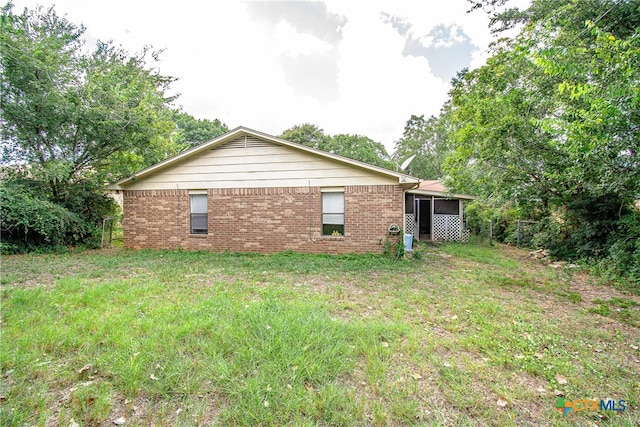 rear view of property featuring a lawn