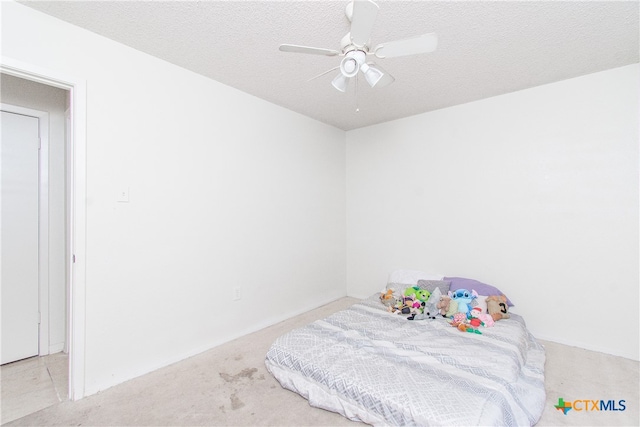 bedroom featuring a textured ceiling, light carpet, and ceiling fan