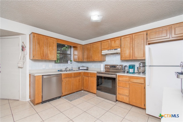 kitchen featuring stainless steel appliances, backsplash, a textured ceiling, light tile patterned floors, and sink