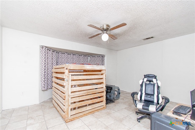 tiled home office with ceiling fan and a textured ceiling