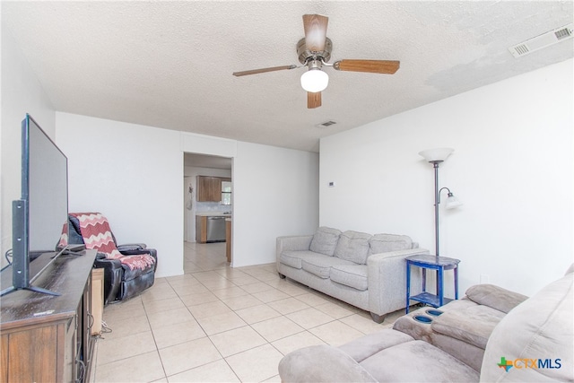 tiled living room featuring ceiling fan and a textured ceiling