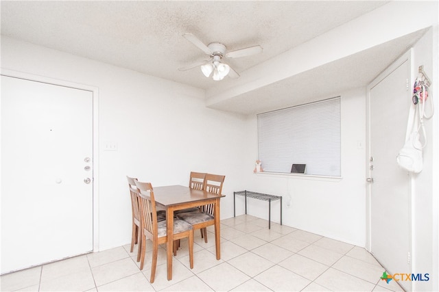 dining space with a textured ceiling, ceiling fan, and light tile patterned floors