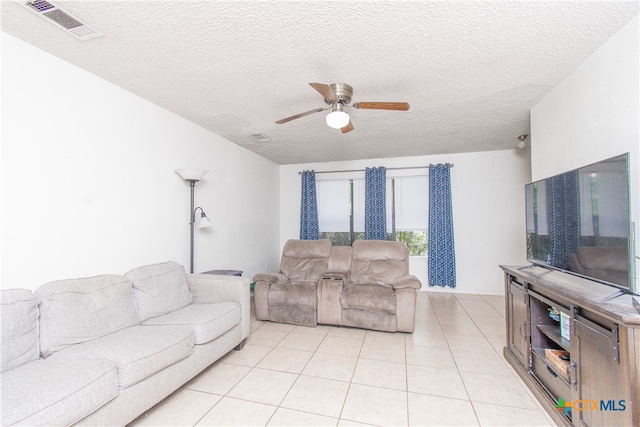 tiled living room with ceiling fan and a textured ceiling