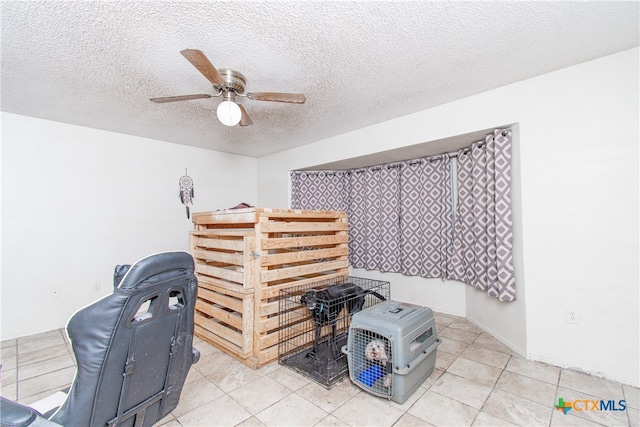 interior space featuring light tile patterned flooring, ceiling fan, and a textured ceiling