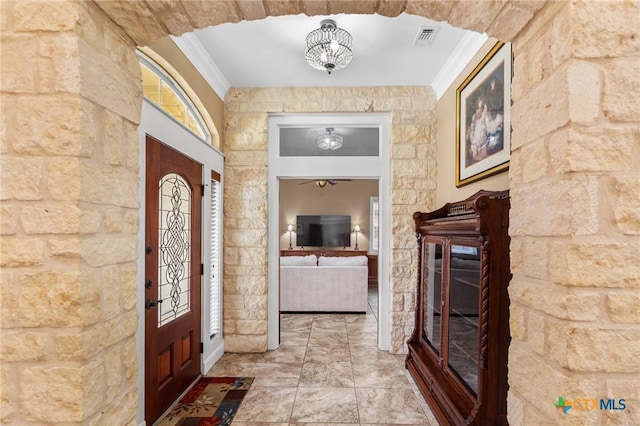 entryway with a ceiling fan, visible vents, and ornamental molding