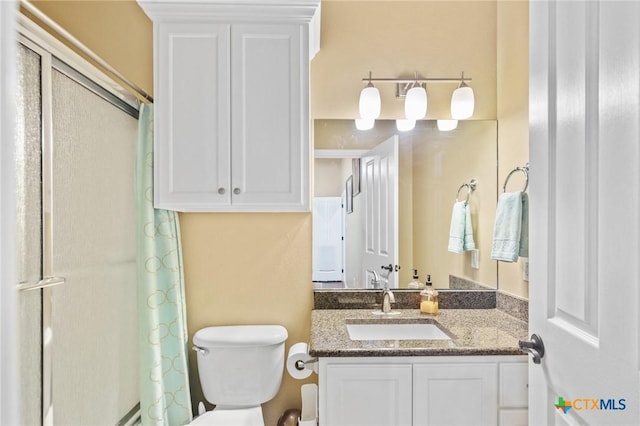 full bath with a shower with curtain, vanity, and toilet