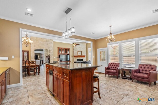 kitchen with a kitchen breakfast bar, ceiling fan with notable chandelier, open floor plan, a fireplace, and visible vents