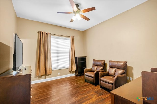 living room with ceiling fan, baseboards, and wood finished floors