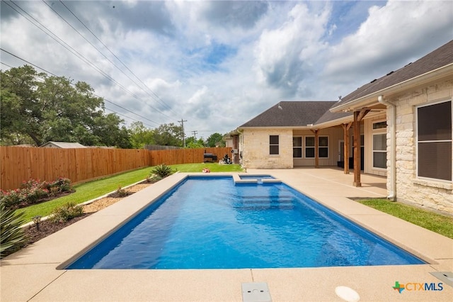 view of swimming pool with a lawn, a fenced backyard, a pool with connected hot tub, and a patio