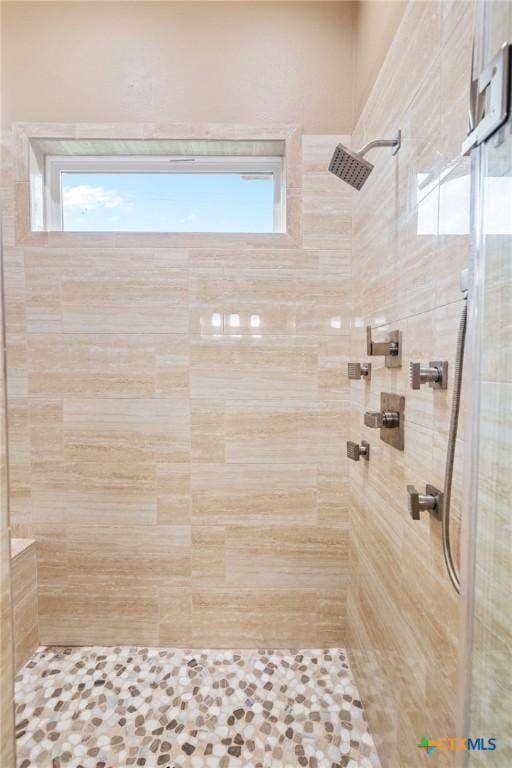 bathroom with a wealth of natural light and tiled shower
