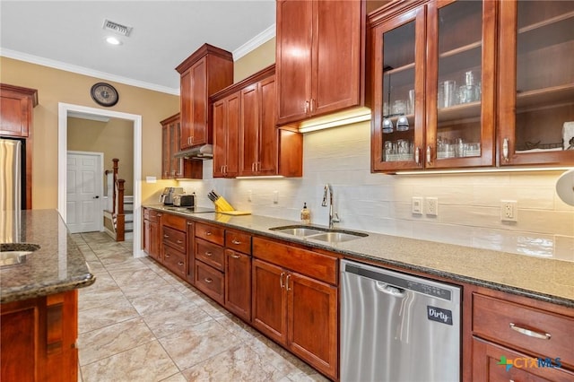 kitchen featuring dark stone counters, a sink, stainless steel appliances, ornamental molding, and visible vents