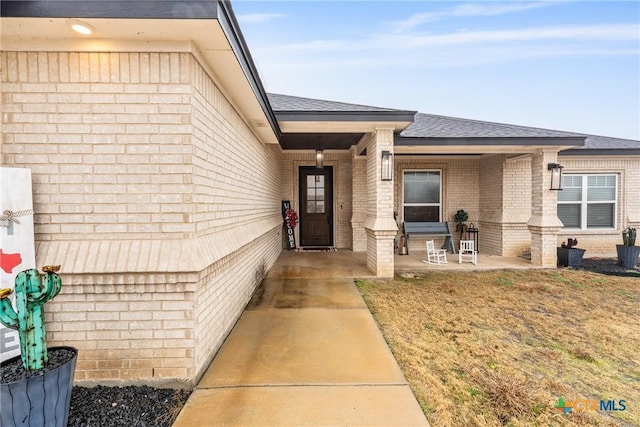 view of exterior entry with a yard