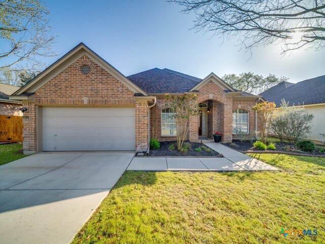 view of front of home with driveway, a front yard, brick siding, a garage, and a shingled roof