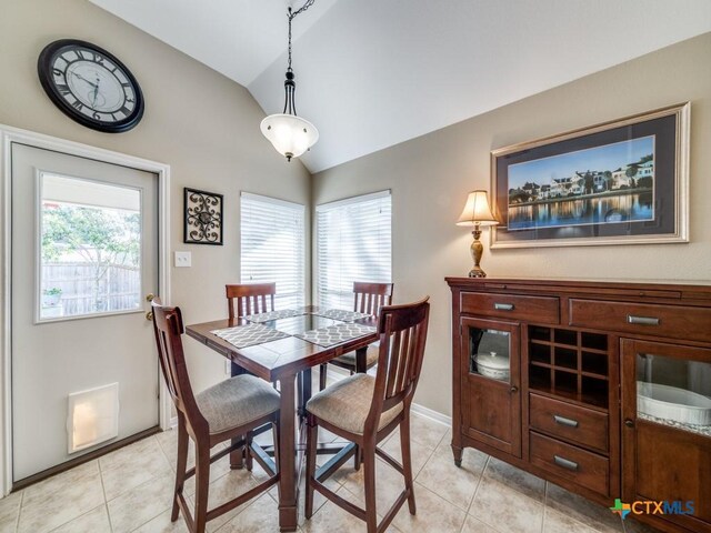 dining space with light tile patterned floors, vaulted ceiling, and a wealth of natural light