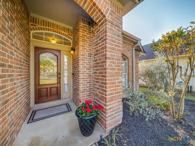 doorway to property with brick siding