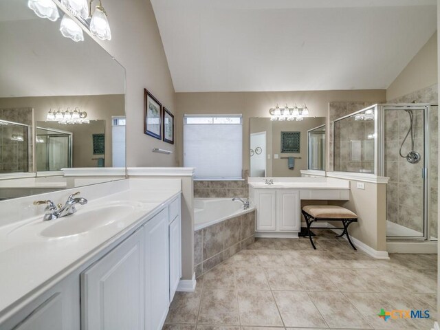 bathroom featuring tile patterned flooring, a sink, lofted ceiling, and a shower stall