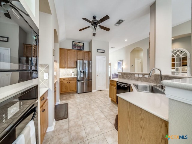 kitchen featuring stainless steel fridge with ice dispenser, arched walkways, a sink, and a ceiling fan