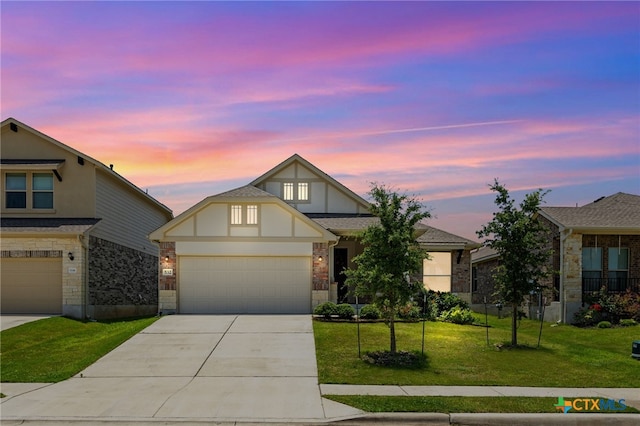 532 Elm Green St, Hutto, TX 78634 - view of front of property with concrete driveway, a yard, a garage, stucco siding, and stone siding