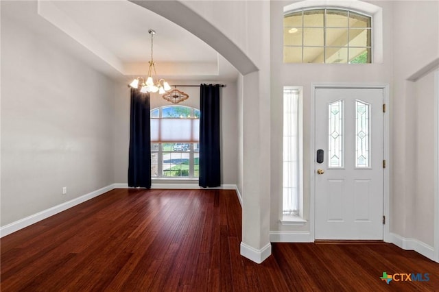 1428 Windcrest Dr, Round Rock, TX 78664 - entrance foyer featuring wood finished floors, a chandelier, baseboards, arched walkways, and a raised ceiling